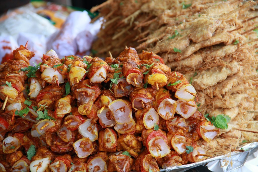 Stand street food illuminati di sera durante il festival del pollo a Torino
